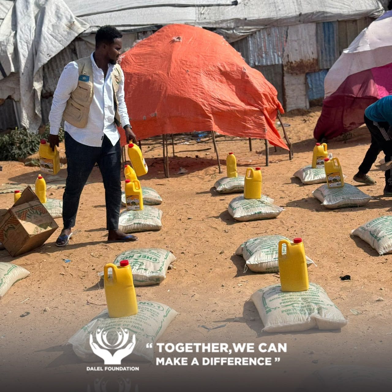 Rows of rice sacks and cooking oil laid out for family food parcel distribution by Dalel Foundation